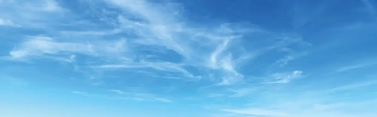 Der Himmel ist klar und blau mit zarten, weißen Wolkenmustern.