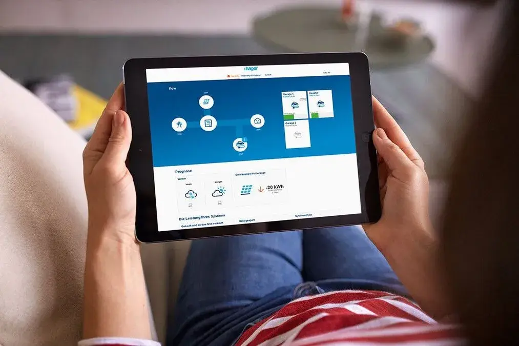 Eine Person hält ein Tablet mit einer Anwendung und zeigt farbige Buttons auf blauem Hintergrund.