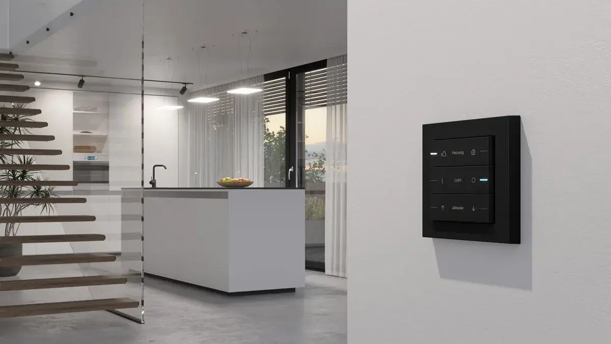 Moderne Küche mit Treppe, schwarzem Wandpanel und offenem Raum.